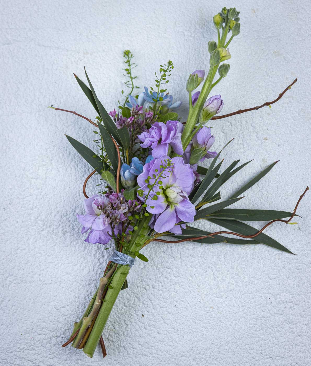 Pystyasentoinen kukkaviehe violetilla leukoijalla ja sinisillä kukilla