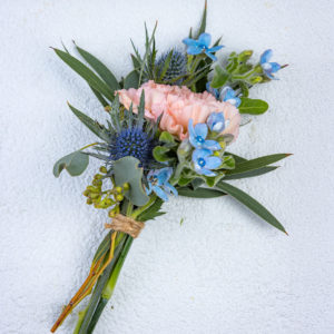 Käsityönä tehty kukkaviehe jossa persikka neilikka ja sininen piikkiputki